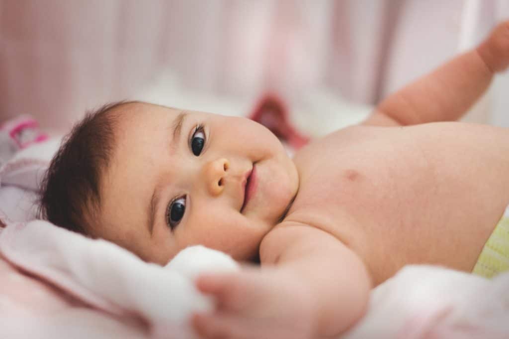 Bébé souriant dans son lit