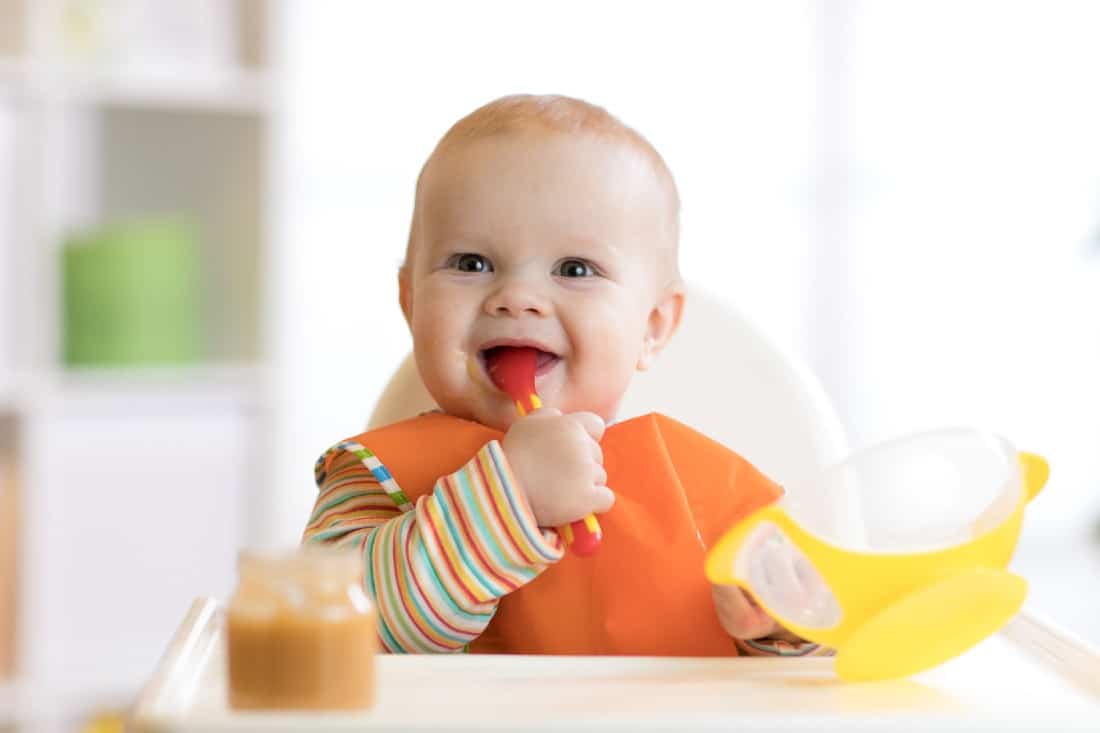 bébé souriant qui mange  