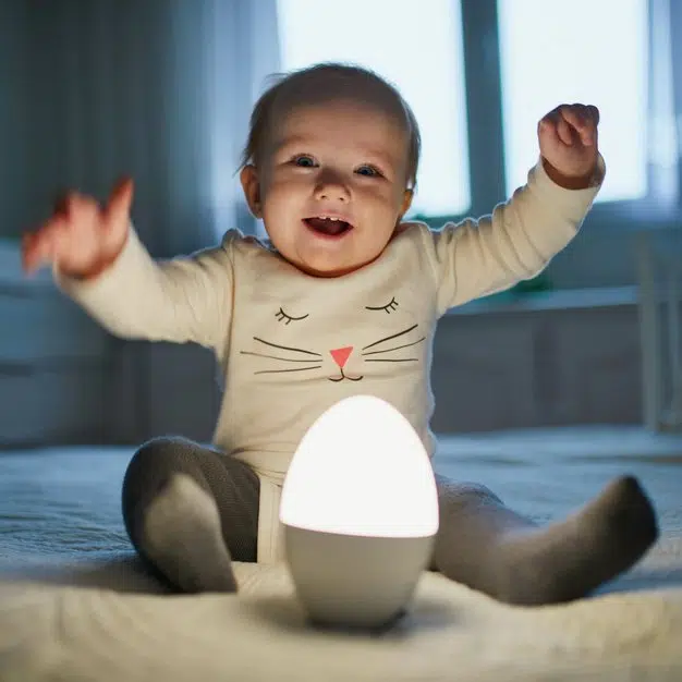 enfant heureux avec la lueur blanche d'une veilleuse en forme d'œuf
