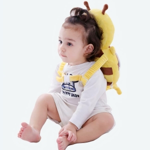 Un bébé avec le cale-tête oreiller de protection en forme d'abeille