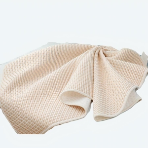 Couverture de matelas à langer pour bébé couleur beige sur un lit de bébé