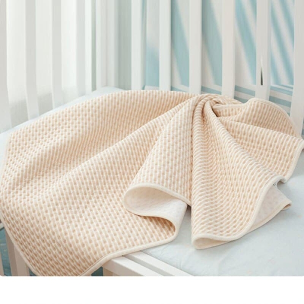 Couverture de matelas à langer pour bébé couleur beige sur un lit de bébé