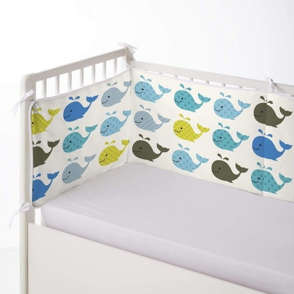 Tour de berceau baleine pour bébé dans un lit et un fond blanc