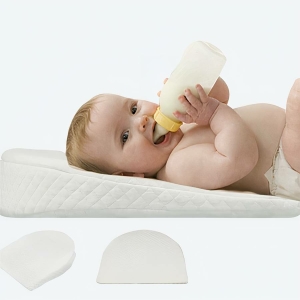 Coussin cale pour nouveau-né avec un bébé qui boit dans un biberon