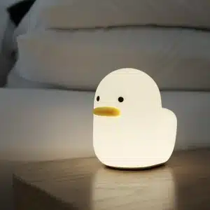 Veilleuse en forme de canard lumineuse en couleur blanche avec un fonds de canapé