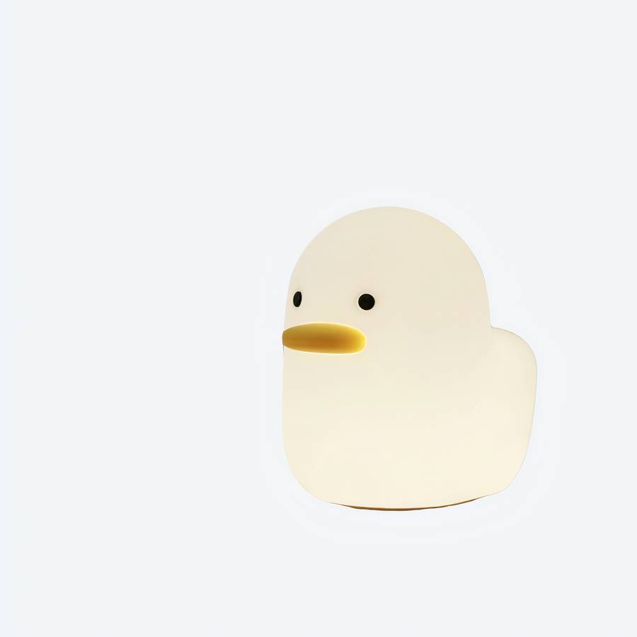 Veilleuse en forme de canard lumineuse en couleur blanche avec un fonds de canapé
