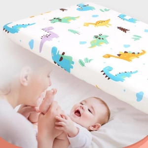 Couverture de matelas avec des motifs dinosaure avec un bébé qui rigole avec sa maman