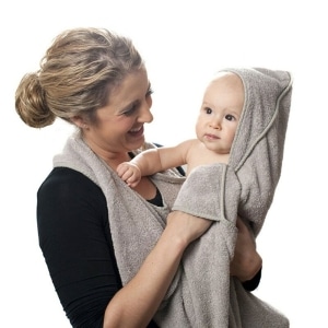 Serviette de bain en coton à capuche de haute qualité pour bébé avec un fond blanc et une maman qui porte son bébé avec la serviette