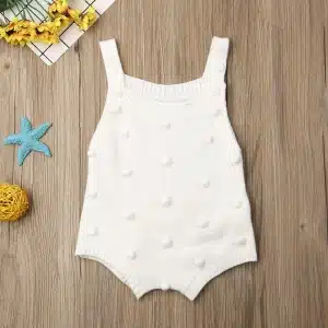Ensemble de vêtements de bébé pour l'été blanc avec un fond en bois marron