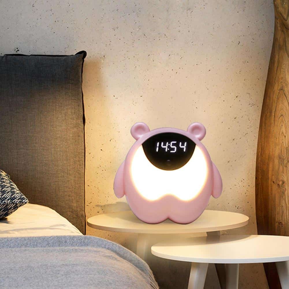 Veilleuse en forme d'ours rose avec horloge sur le côté du lit