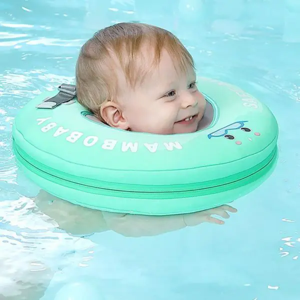 Un bébé qui rigole et qui porte l'anneau de natation gonflable qui est vert