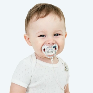 Sucette avec attache-tétine personnalisée avec un bébé qui porte la tétine