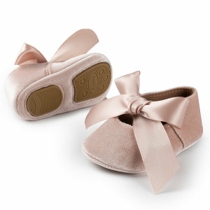 Petites chaussures ballerines pour petites filles. Elles sont marrons avec une semelle anti-dérapante. Un gros noeud sur l'avant du modèle qui couvre une petite ouverture pour le pied.
