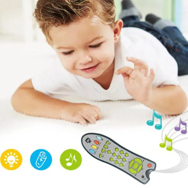 Un bébé qui jouet avec la telécommande musicale