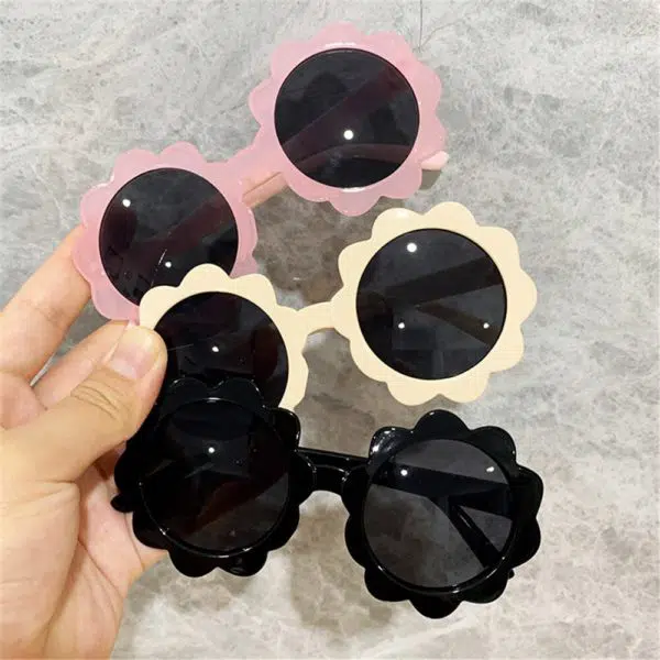 Petites lunettes ronde pour bébé. Elles ont une forme de fleurs autour des verres. La monture est épaisse et les verres sont foncés pour protéger du soleil. Le choix de couleur peut se faire sur du rose, jaune ou noir.