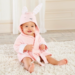 Un bébé qui porte le peignoirs rose à capuche en forme de lapin pour bébé