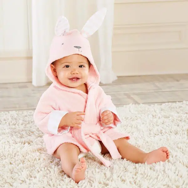 Un bébé qui porte le peignoirs rose à capuche en forme de lapin pour bébé