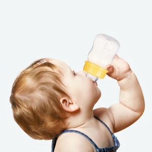 Un bébé qui boit dans le mini biberon d'allaitement naturel