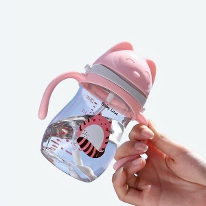 Biberon en silicone avec poignée rose à motif animal mignon avec un fond bleu et une main qui tient le biberon