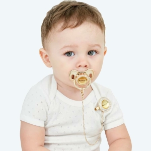 Sucette avec attache-tétine et un bébé qui porte la tétine