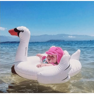 Anneau de natation gonflable d'été pour bébé avec un bébé qui porte l'anneau gonflable avec un fond plage
