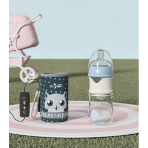 Biberon en verre avec isolation USB pour bébé dans un jardin avec une poussette rose dans le fond