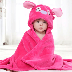 Un bébé tout mignon qui est avec le peignoir de bain à capuche et à motif de dessin animé rose