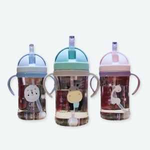 Biberon standard anti-coliques pour bébé un rose, un vert et un bleu avec un fond d'un grand espace avec lumier et table