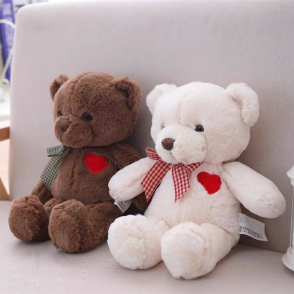 Deux ours en peluche pour bébé un marron et un blanc dans le canapé