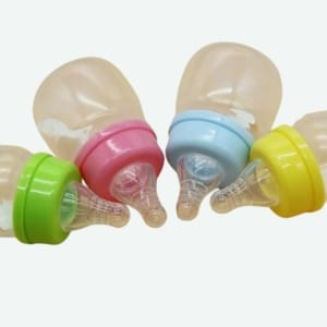 Biberon d'allaitement pour bébé un rose et un bleu avec un fond jaune