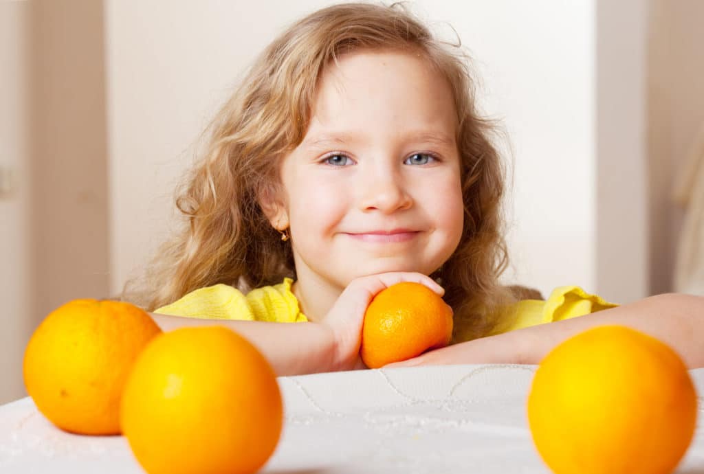 Fille souriante avec des oranges