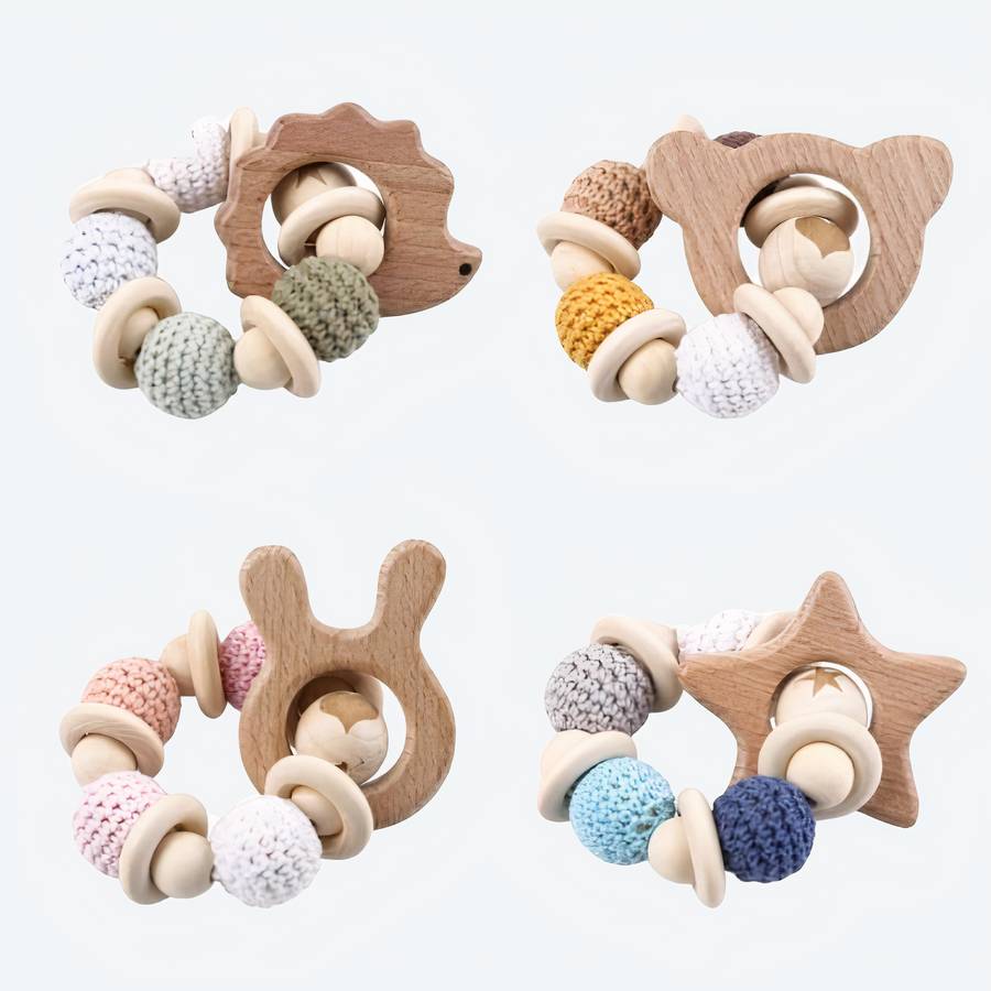 Bracelet hochet en bois pour bébé a plusieurs formes différentes avec un fond blanc
