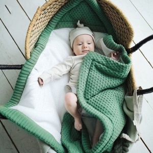 Sac de couchage collection hiver pour bébé vert avec un bébé qui dort sur le panier