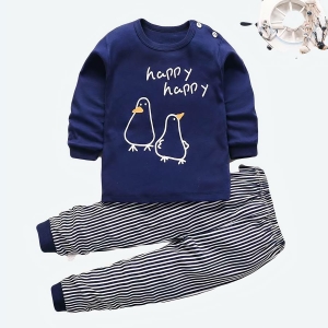 Pyjama bleu pour bébé avec pingouins avec un fond en bois blanc et des fleurs