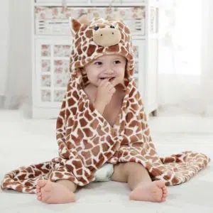 Cape de bain petit girafeau avec un bébé qui porte la cape avec un fond une salle de bain