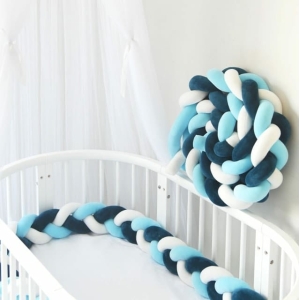 Tour de lit tressé bleu blanc dans le mur sur le lit d'un bébé
