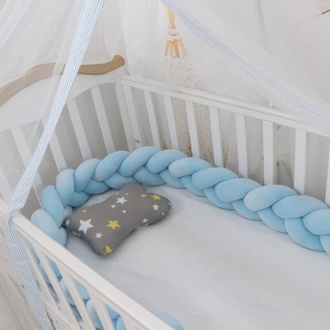 Tour de lit tressé bleu dans un lit de bébé