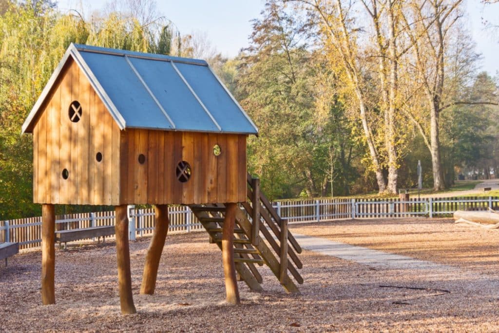 une cabane en bois en extérieur devant une forêt