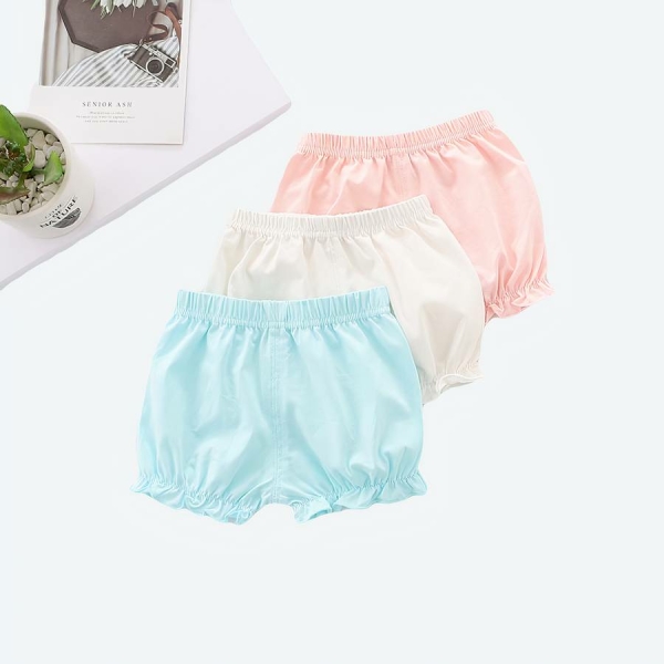 Short bouffant en coton couleur unie pour bébé un bleu, un blanc et un rose avec un fond avec une plante et un livre