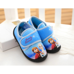 Chaussures Anna et Elsa La Reine des neiges pour bébé poser dans un lit blanc de bébé