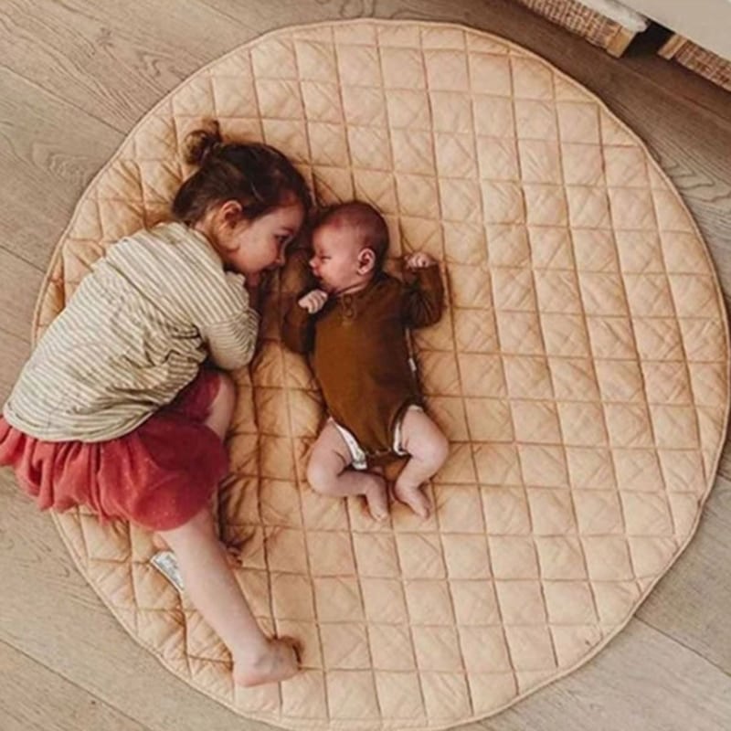 Deux enfant allongé sur un tapis rond beige