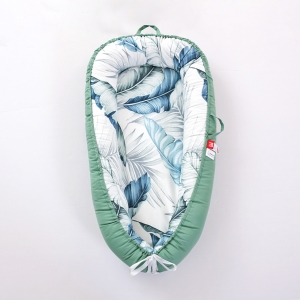 Réducteur de lit pour bébé avec le tour bleu et l'intérieur avec motif de grandes feuilles bleues