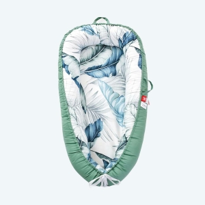 Réducteur de lit pour bébé avec le tour bleu et l'intérieur avec motif de grandes feuilles bleues