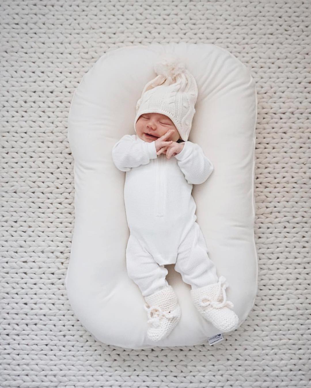 Petit bébé endormi et installé dans un réducteur de lit