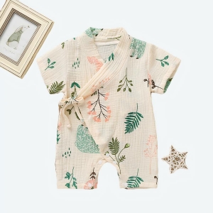 Body style kimono beige avec motif fleural pour bébé avec lunette de vue posées à gauche et un cadre photos