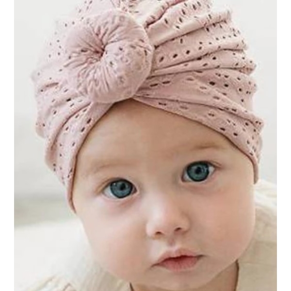 Petite fille qui porte un turban sur la tête avec un petit noeud sur le front , beige à trou