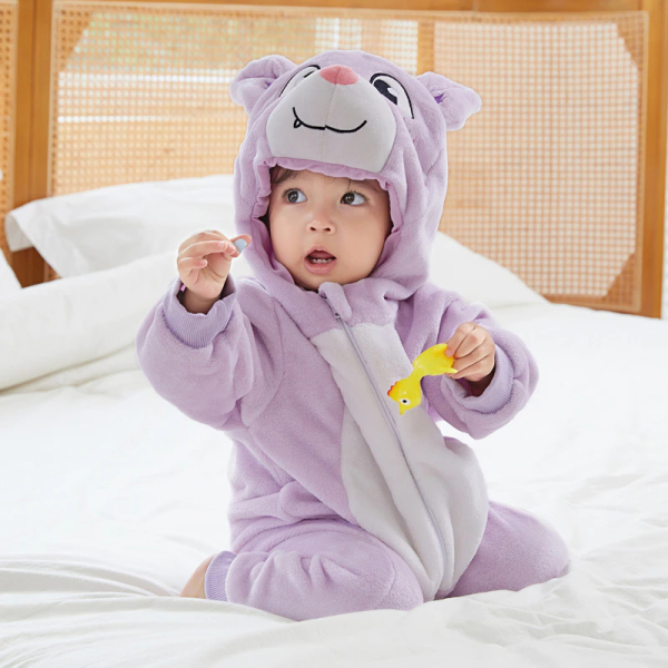 Pyjama chaud en polaire d'animaux pour bébé violet avec un bébé qui porte le pyjama dans le lit