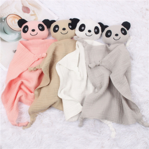 plusieurs doudou pour enfant en chiffon avec une tête de panda mignon sont posés les une près des autres, un rose , un beige, un blanc et un gris , posés sur un tissu