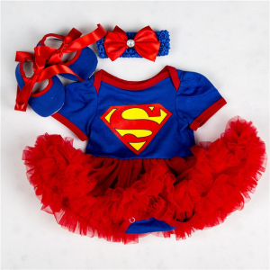 déguisement de super man pour bébé fille avec un body manches courtes et des volants rouges ,posé à plat sur fond blanc, au dessus sont posés des chaussons assortis et un bandeau avec un noeud