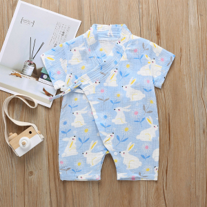 Tenue d'été style kimono bleu à motif lapin pour les bébés, posée à plat avec un appareil photo et une affiche